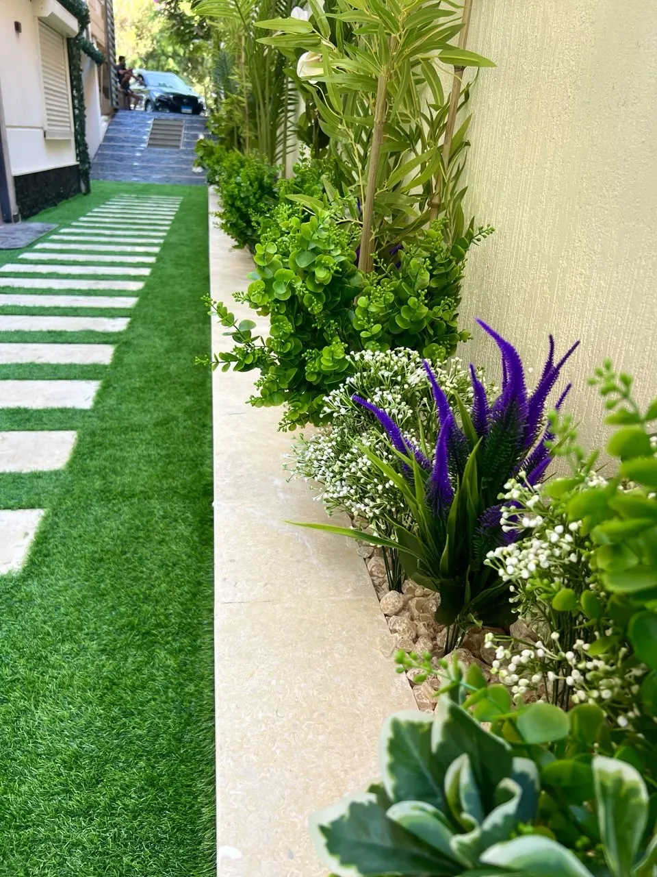 Uplighting along the planted side garden after dark