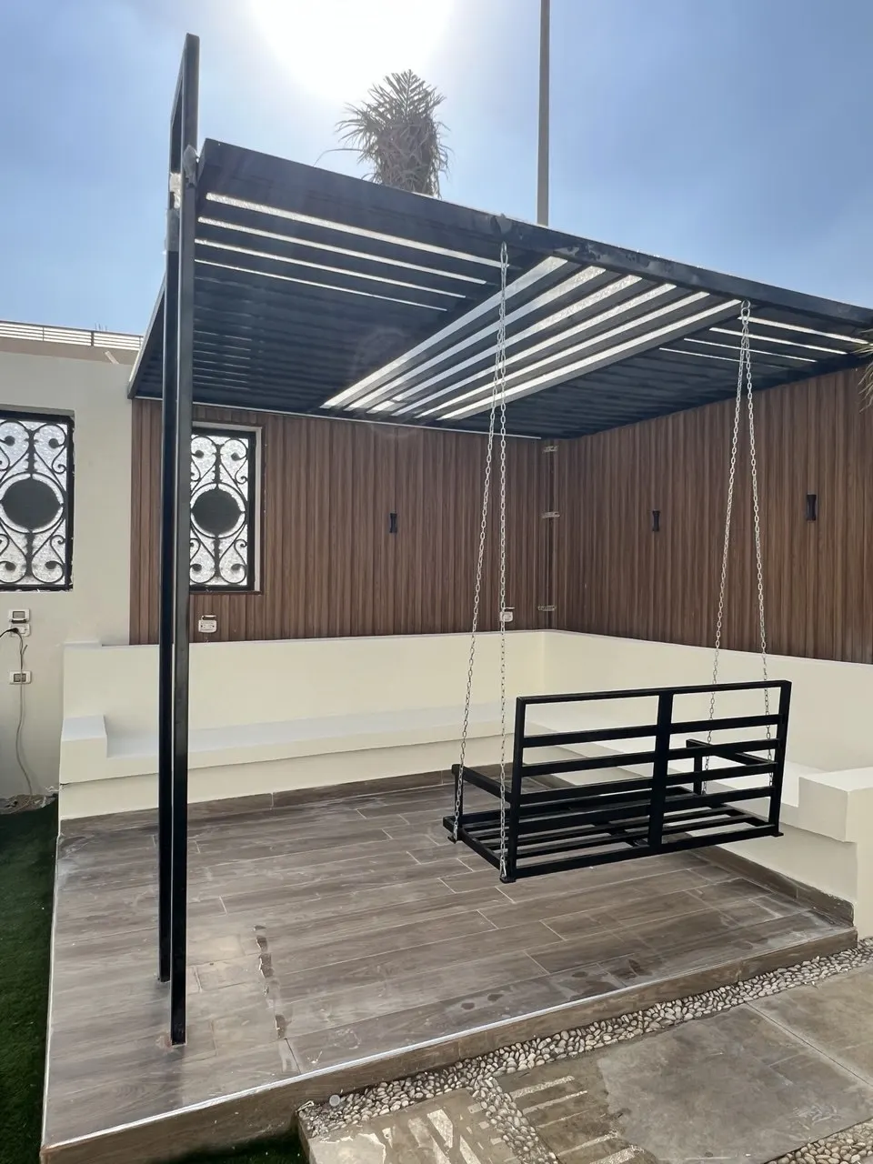 Timber deck and paved terrace beside a villa pool